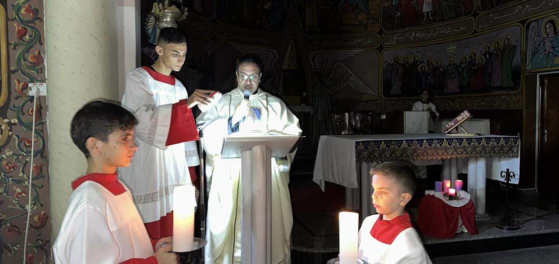 الأب يوسف أسعد، الكاهن في كنيسة العائلة المقدسة في غزة، يحتفل بالقداس اليومي بدون كهرباء