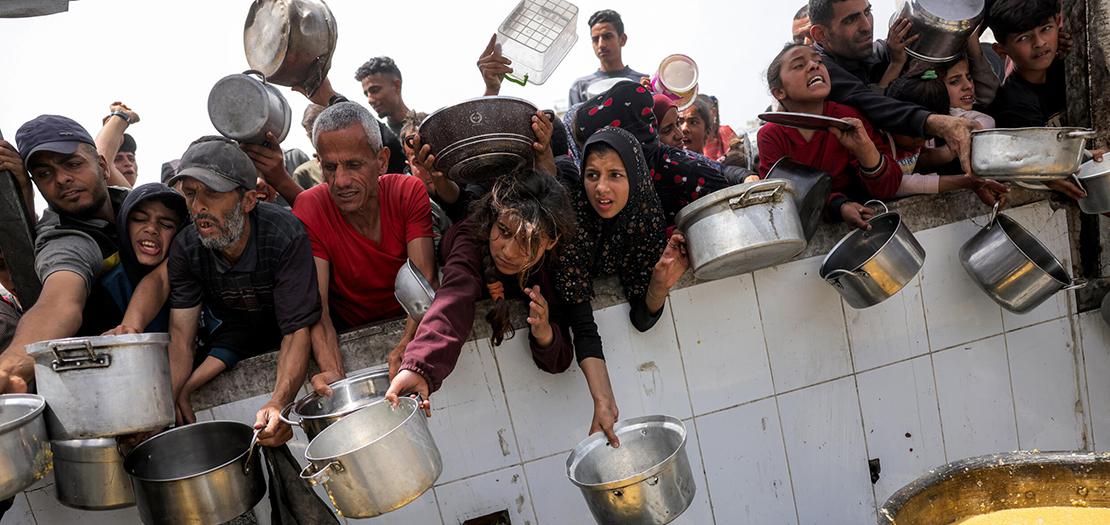 أشخاص ينتظرون أمام تكية طعام خيرية في بيت لاهيا في شمال قطاع غزة، 24 نيسان 2025